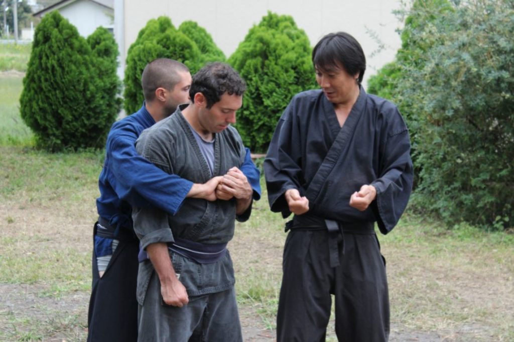 Kiyomoto (left) teaches how to strike back when assaulted from behind.
