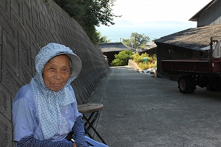 The elderly female islander smiles in greeting.