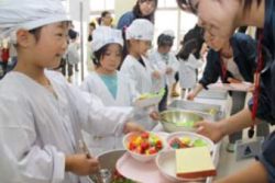 Japanese elemenntary school children serving school lunches in their classroom